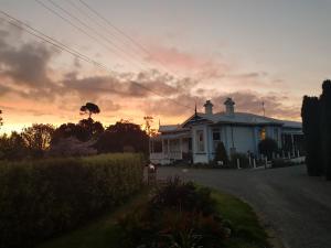a white house with a sunset in the background at Lancewood Lodge in Bulls