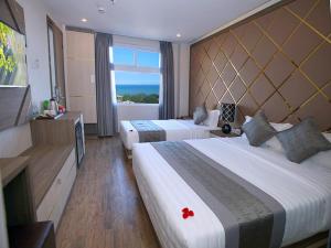 a hotel room with two beds and a window at New Sun Hotel in Nha Trang
