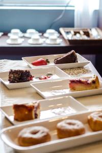 a table with plates of different types of desserts at Santa Teresita Boutique Hotel in San Fernando