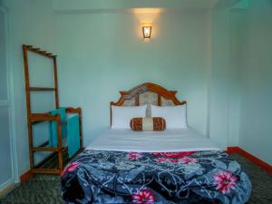 a bedroom with a bed with a wooden head board at Namadi Nest Nuwara Eliya in Nuwara Eliya