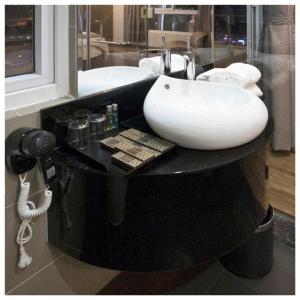 a bathroom with a white sink on a black counter at New Sun Hotel in Nha Trang