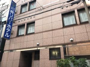 a building with a street sign in front of it at Kawasaki River Hotel in Kawasaki