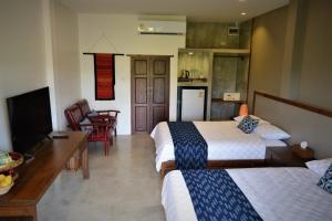 Habitación de hotel con 2 camas y TV en Le Cocotier, en Ban Cho Lae