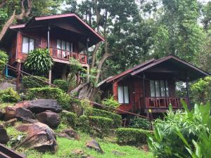 two bamboo cabins in a forest with rocks at Phi Phi Green Hill Resort in Phi Phi Don