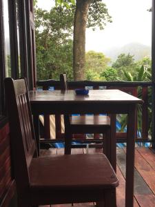 a wooden table and chairs on a porch with a window at Phi Phi Green Hill Resort in Phi Phi Islands