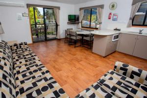 a living room with a kitchen and a table with chairs at BIG4 Shepparton Park Lane Holiday Park in Shepparton