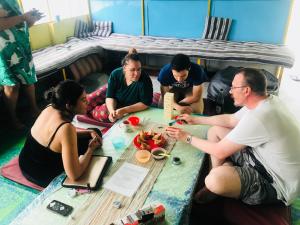 a group of people sitting around a table at The Little Blue Window Hostel in Bangalore