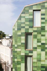 ein grünes Gebäude mit Seitenfenstern in der Unterkunft Hyatt Regency Amsterdam in Amsterdam