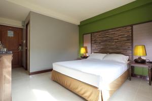 a bedroom with a large white bed and green walls at Rambuttri Village Plaza in Bangkok