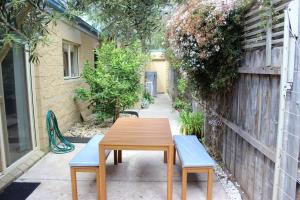 a wooden table and two blue benches in an alley at Annie's Place in Cowes