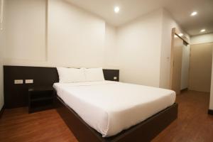 a bedroom with a large bed with white sheets at PSB1 Apartment in Bangkok