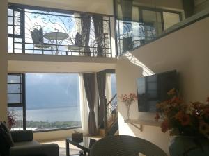 a living room with a large window and a tv at Home Bird Garden Villa in Dali