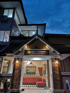 une maison avec un balcon et un banc rouge dans l'établissement SABUN-NGA HOSTEL, à Chiang Rai