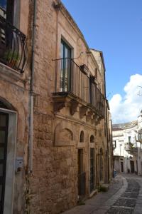 an old stone building with a balcony on a street at PIETRAVIVA in Ragusa
