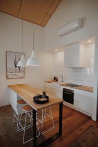 a kitchen with a wooden table and chairs in it at THE WAREHOUSE APARTMENTS in Geelong +12 photos