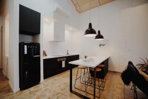 a kitchen with a white counter and a black refrigerator at THE WAREHOUSE APARTMENTS in Geelong