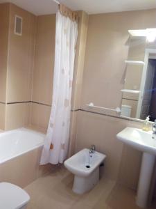 a bathroom with a tub and a toilet and a sink at Apartmento playa Almarda. Piscina&Parking in Almarda