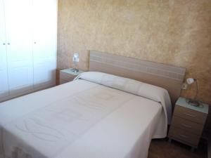 - une chambre avec un grand lit blanc dans l'établissement Apartmento playa Almarda. Piscina&Parking, à Almardá