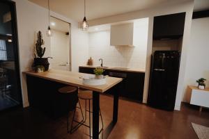 
a kitchen with a table and a refrigerator at THE WAREHOUSE APARTMENTS in Geelong
