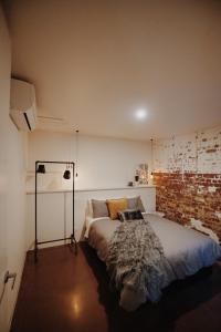 a bedroom with a bed and a lamp on the wall at THE WAREHOUSE APARTMENTS in Geelong