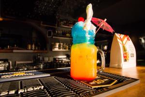 a drink in a bottle on a bar with an umbrella at Pili Pili Beach Cabanas in Sedgefield