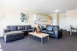 uma sala de estar com dois sofás e uma mesa de centro em Perth Ascot Central Apartment Hotel Official em Perth