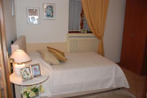 a small bedroom with a white bed and a window at Casa Fantasia in Tremezzo
