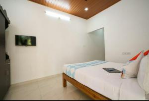 um quarto com uma cama com um computador portátil em Munnar Minds Homestay em Munnar