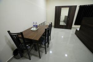 uma mesa de madeira e cadeiras num quarto em Shivalaya Residency em Thrissur