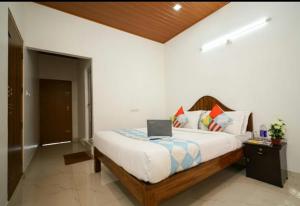 um quarto com uma cama com um computador portátil em Munnar Minds Homestay em Munnar