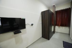 a flat screen tv on a wall in a room at Shivalaya Residency in Trichūr