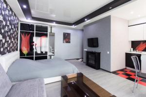 a bedroom with a bed and a tv and a couch at Luxury Studios on Nauki Avenue in Kharkiv