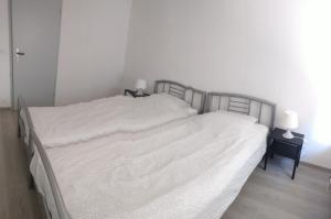 ウェンドゥイネにあるWenduine op zeedijkの白いシーツが備わるベッドルームのベッド2台