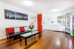 a living room with a black couch and a table at Perth Ascot Central Apartment Hotel Official in Perth