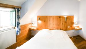 a bedroom with a white bed and two night stands at B&B La Ferme de l'Hosté in Wavre