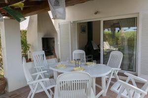 uma mesa branca e cadeiras brancas num pátio em 3 bedroom house in Platja de Pals w/ garden and shared pool (H35) em Pals