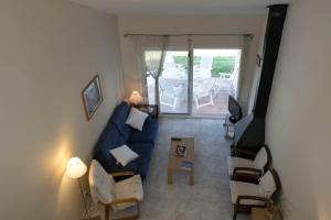 uma sala de estar com um sofá azul e cadeiras em 3 bedroom house in Platja de Pals w/ garden and shared pool (H35) em Pals