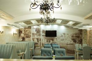 een vergaderzaal met stoelen en een kroonluchter bij Triumph Hotel in Rudny