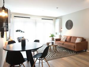 
a living room filled with furniture and a table at BizStay Helena at Sea Apartments in Scheveningen
