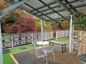 a pergola with a table and chairs on a patio at White House in Sokcho