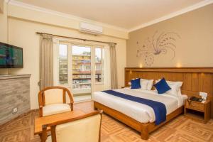 una camera da letto con un letto grande e una finestra di Hotel Lotus Inn a Pokhara