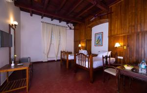 a room with a bedroom with two beds and a desk at Dutch Bungalow in Cochin