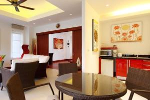 a kitchen and a living room with a table and chairs at Villa Samba Victoria Resort, Koh Yao Noi in Ko Yao Noi