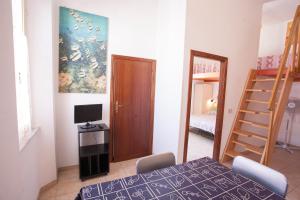 a room with a table and a bed and a ladder at Appartamenti Sole e Luna in Rio Marina