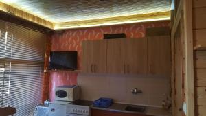 cocina con armarios de madera y microondas en Apartman "Athos" prizemlje, en Višegrad