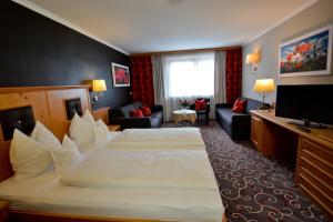 a hotel room with a large bed and a television at Hotel Rettenberg in Kolsass