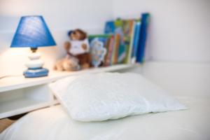 a bed with a pillow and a lamp and books at Deichhaus Brisinga in Breege