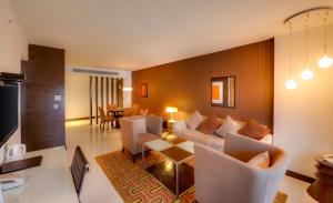 a living room with a couch and chairs at Pride Premier Bengaluru in Bangalore