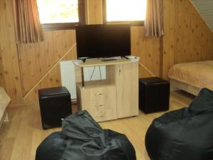 a bedroom with a tv and a bed and a table at Casa Haiducilor in Predeal