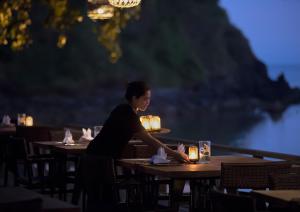 a woman sitting at a table in a restaurant at Jeeva Klui Resort in Senggigi